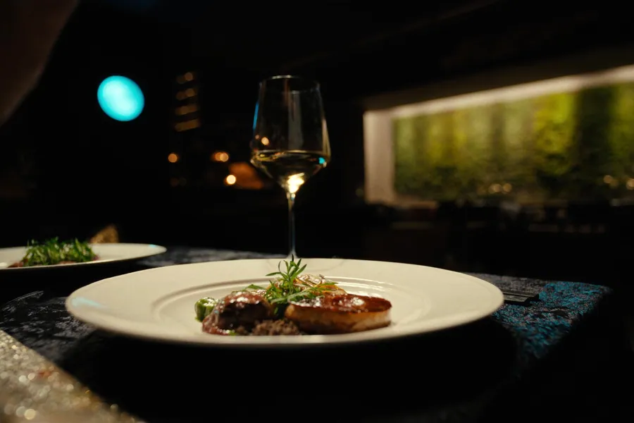 An elegantly plated fine dining dish on a candlelit table